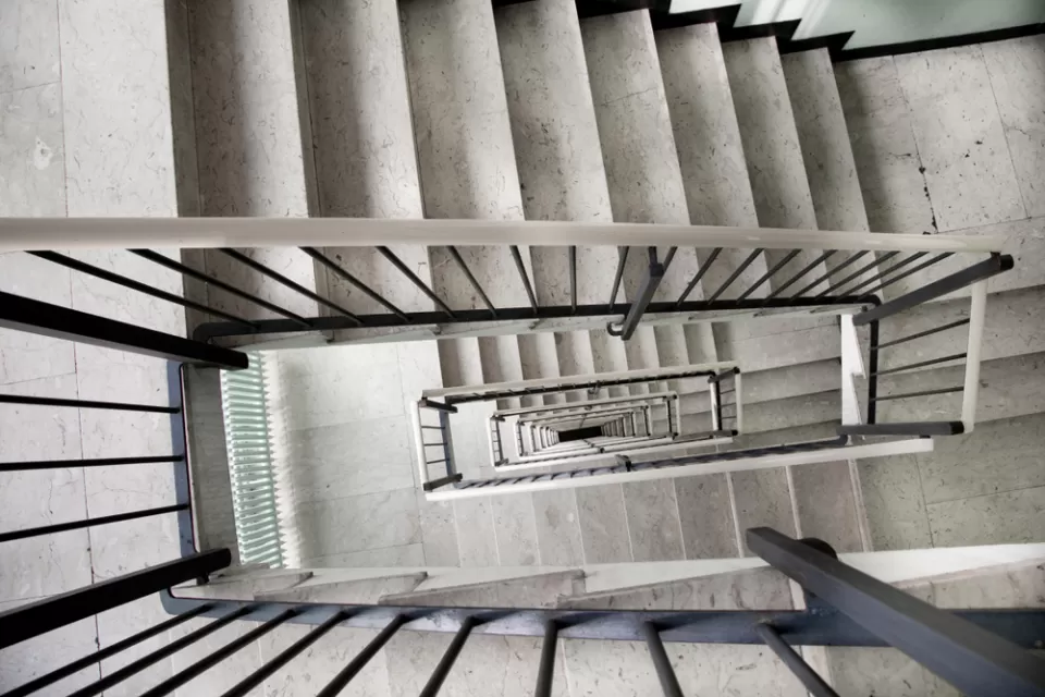 View looking down a multi-story apartment building staircase